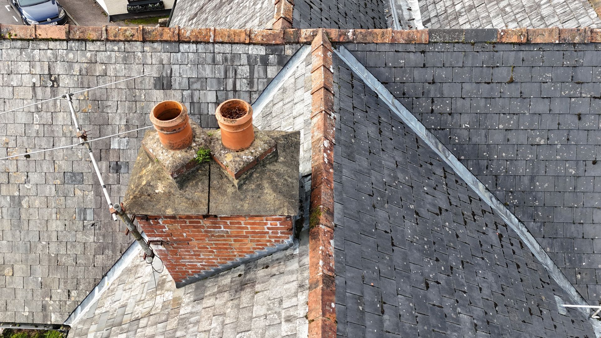 Aerial drone photograph of an old property taken as a drone roof survey showing slate tiles and, ridge tiles.