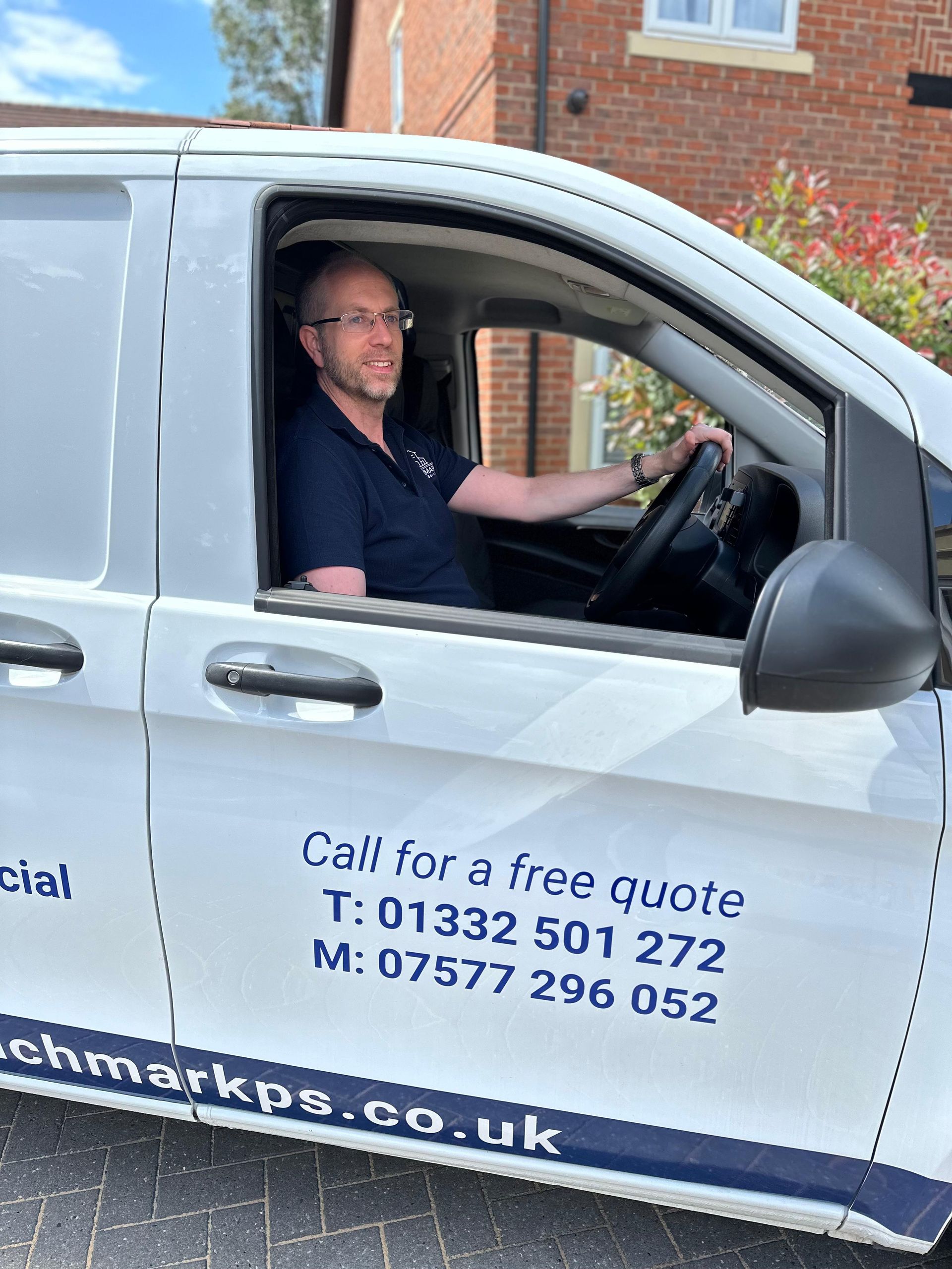 Photo of John Simpson - Director, sat in Benchmark sign written van