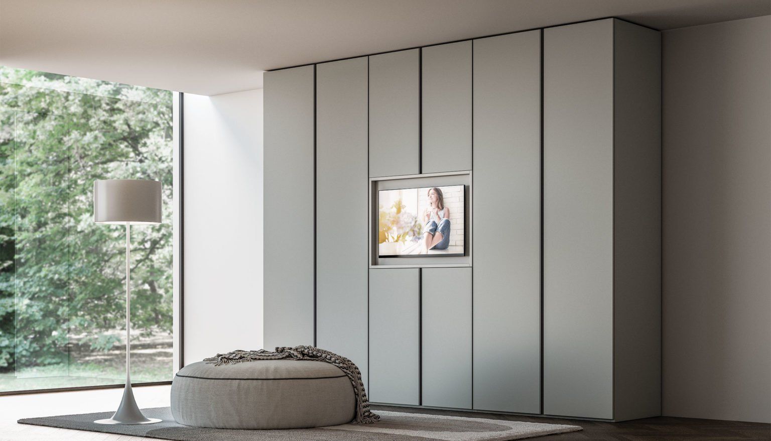 Moderna camera da letto con armadio azzurro incorporato e televisore, accanto a una grande finestra e a una zona salotto.