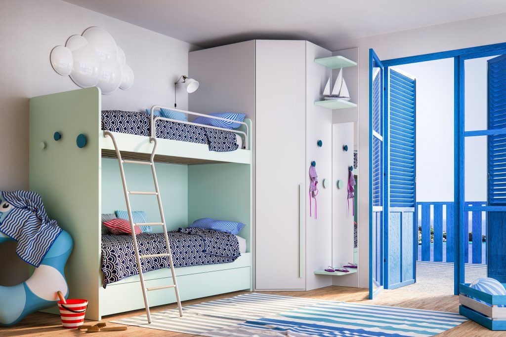 Camera da letto per bambini con letti a castello, dettagli blu, decorazioni a forma di nuvole e un tappeto a righe blu e bianche.