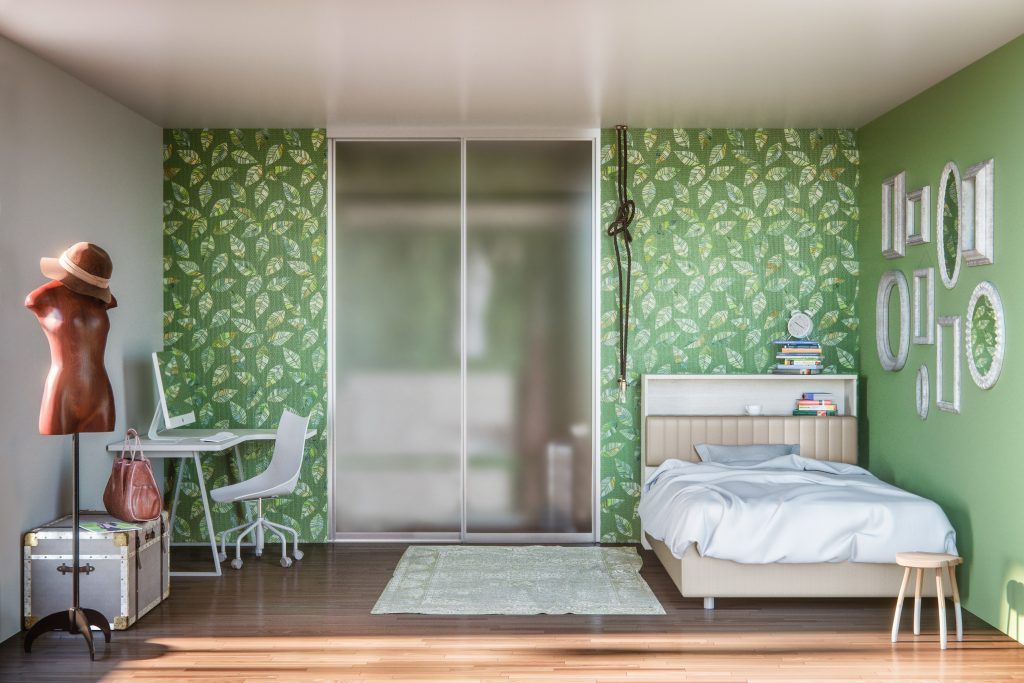 Interno della camera da letto con carta da parati a foglie verdi, letto, scrivania, manichino e specchi con cornice.