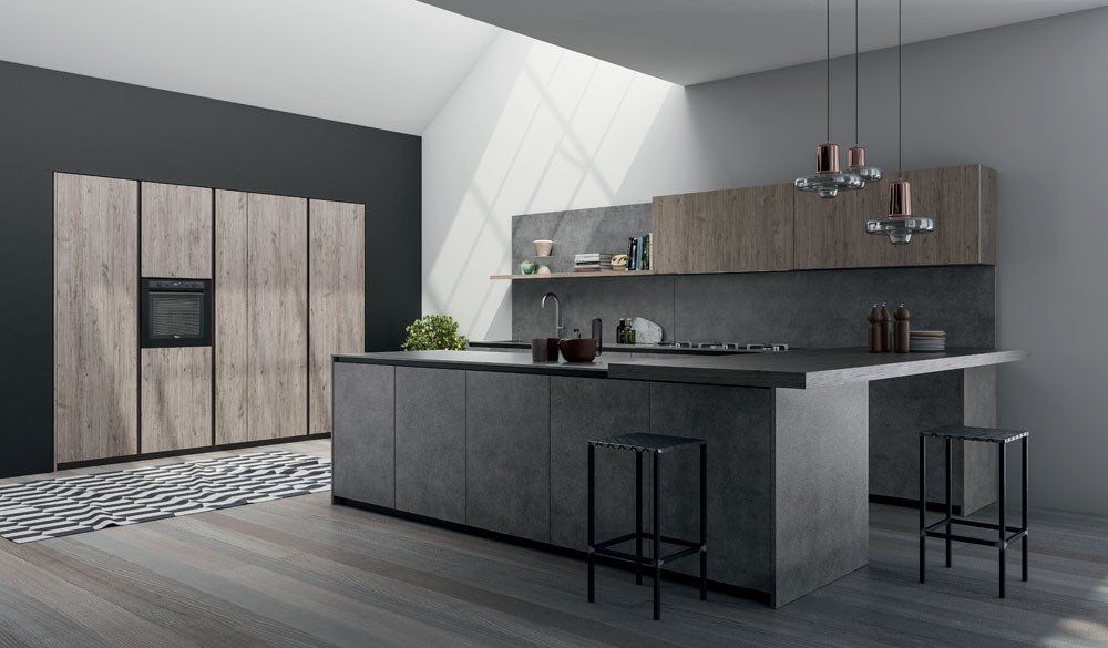 Cucina moderna con isola in cemento, mobili in legno e pareti grigie; due sgabelli da bar.