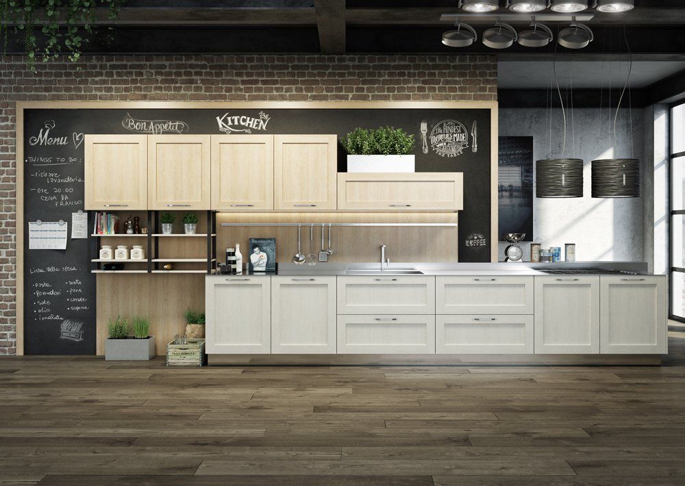 Cucina moderna con mobili in legno chiaro, ripiani in acciaio inossidabile e parete in mattoni.