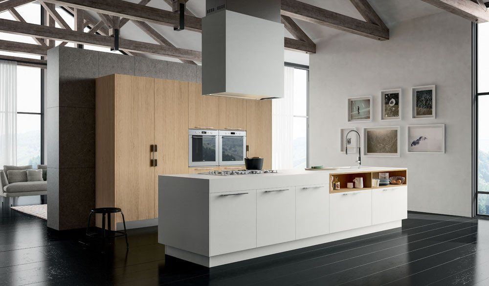 Cucina moderna con isola bianca, mobili in legno e ampie finestre.