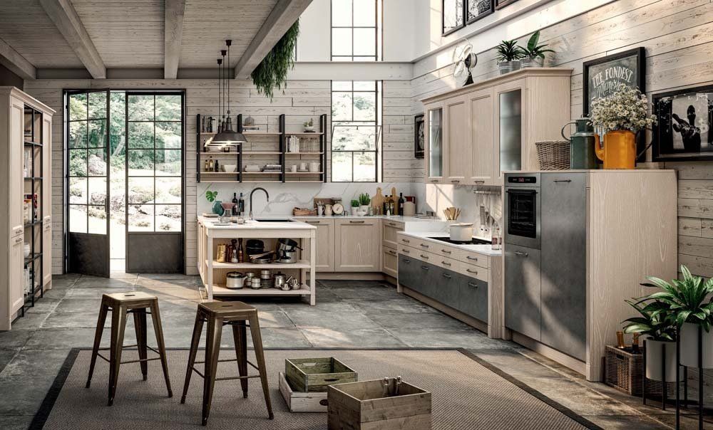 Cucina rustica con mobili in legno, dettagli in metallo, travi a vista e una grande finestra.