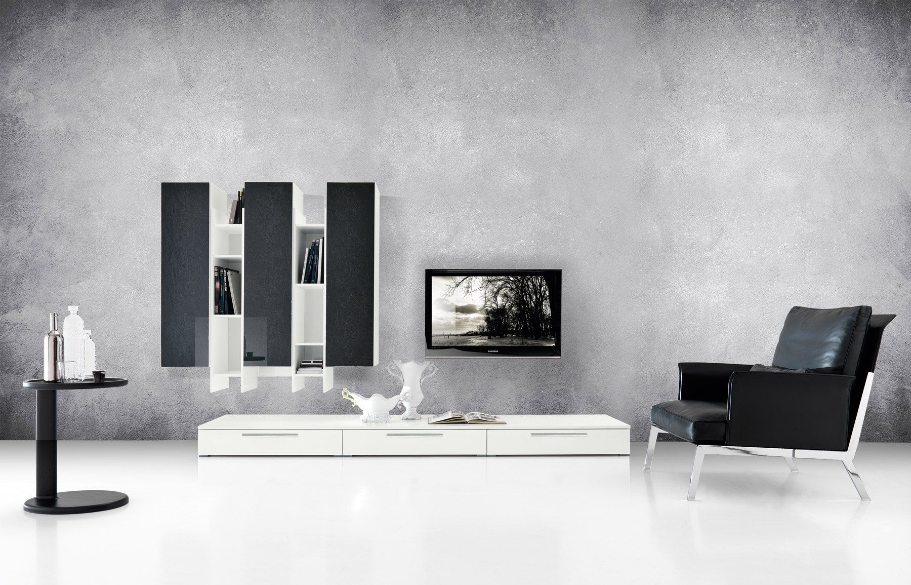 Soggiorno moderno con TV a parete, mobili bianchi, poltrona nera e parete con texture grigia.