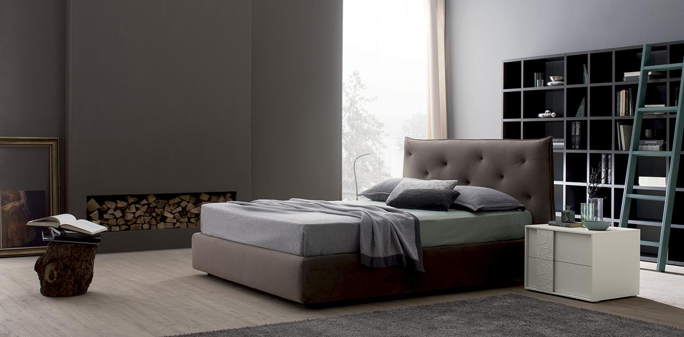 Camera da letto con letto, libreria, camino e comodino bianco. Colori neutri.