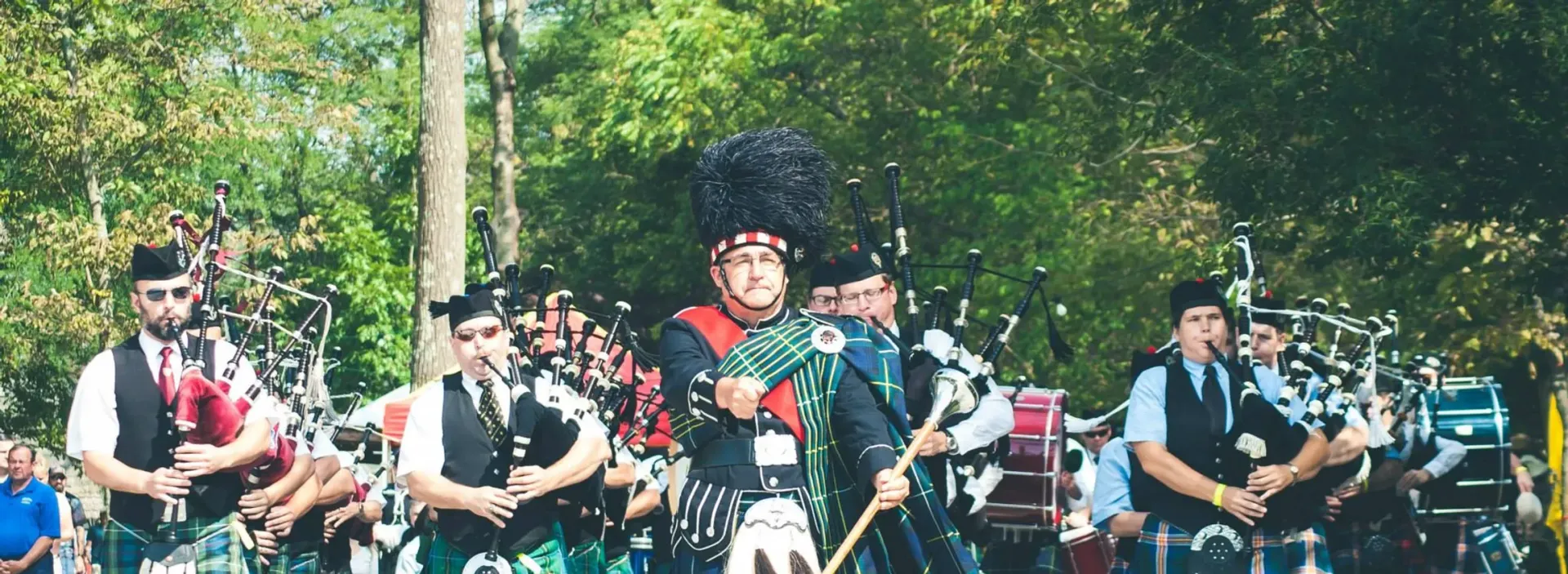 A group of men are playing bagpipes in a parade.