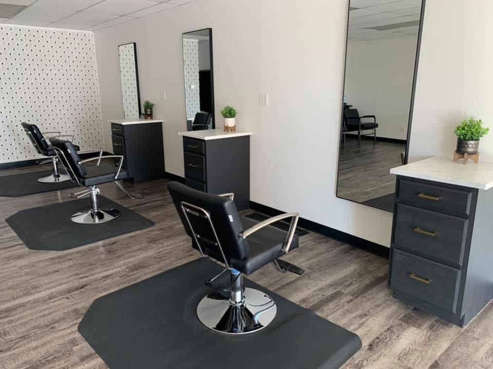 A salon with a lot of chairs and mirrors.