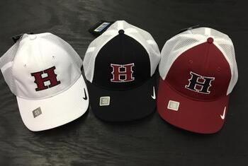 Three hats with the letter h on them are sitting on a table.