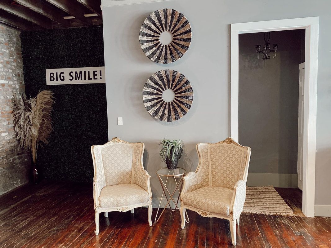 Two chairs are sitting next to each other in a room with a sign on the wall that says `` big smile ''.
