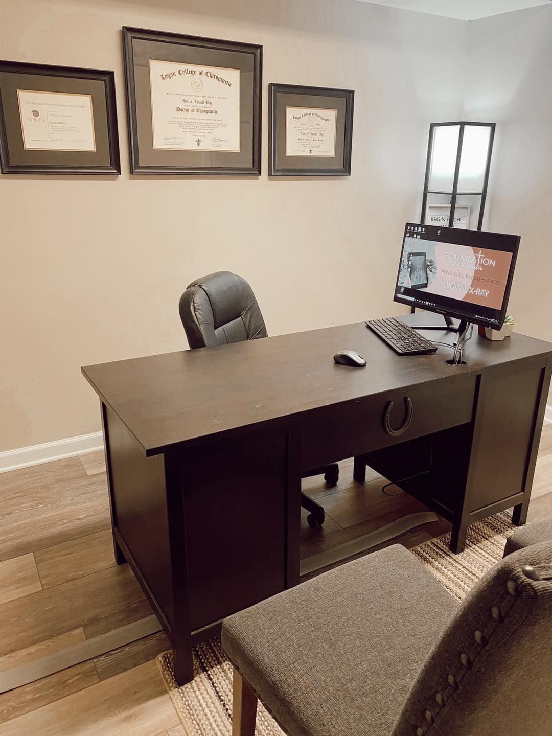 A desk with a computer and a chair in a room.