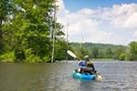 A person is riding a kayak on a river.