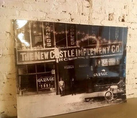 A black and white photo of the new castle implement co.