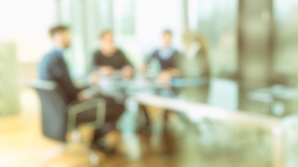 A blurry picture of a group of people sitting around a table.