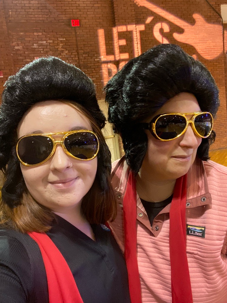 Two people wearing wigs and sunglasses are posing for a picture.