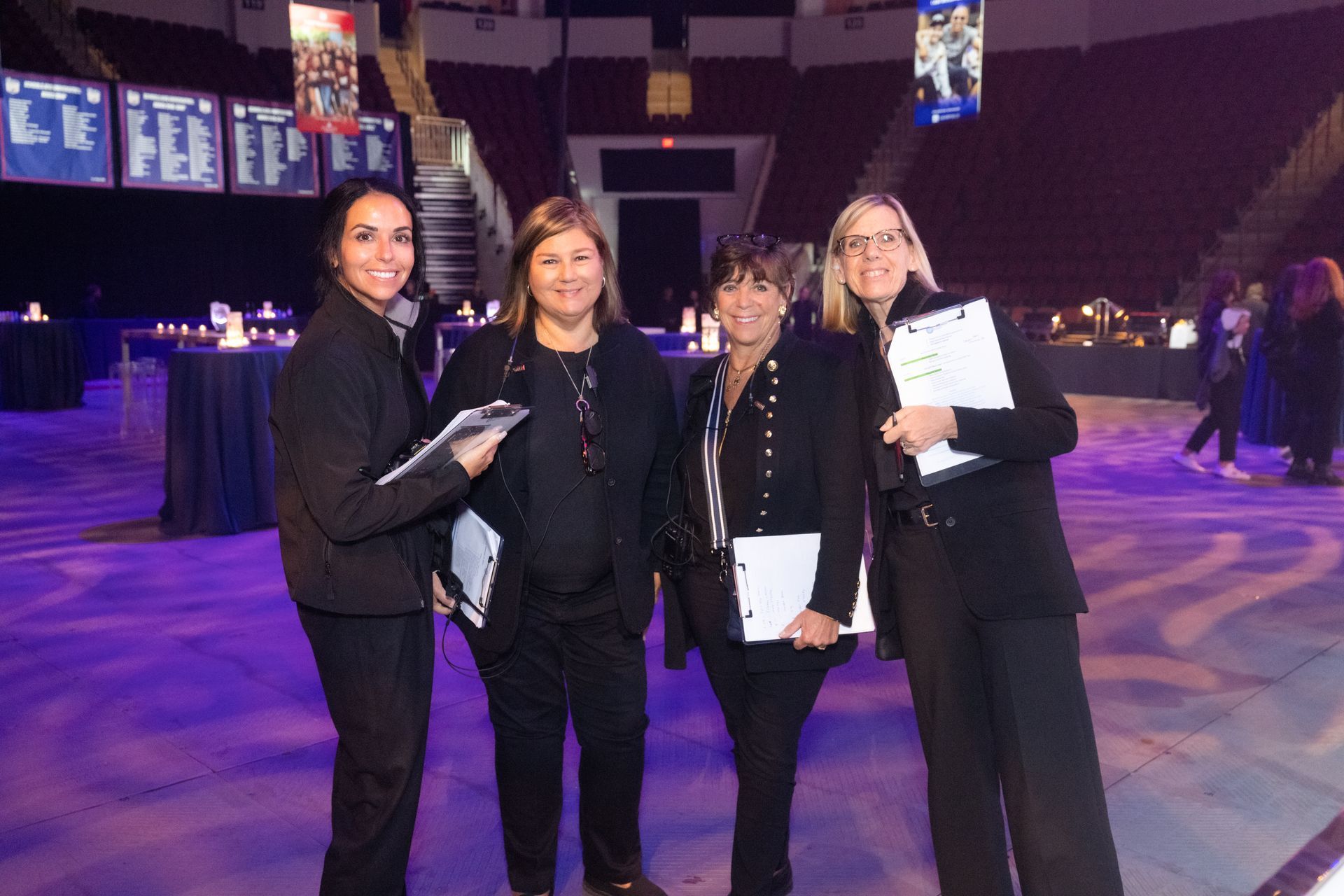 A group of women are posing for a picture in a stadium.