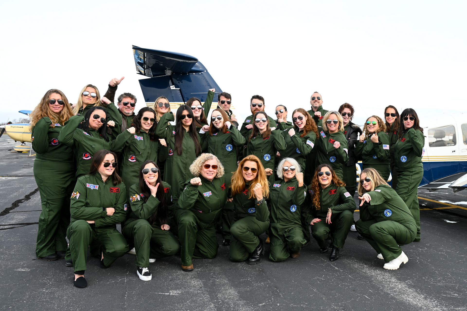 A group of people posing for a picture in front of a plane