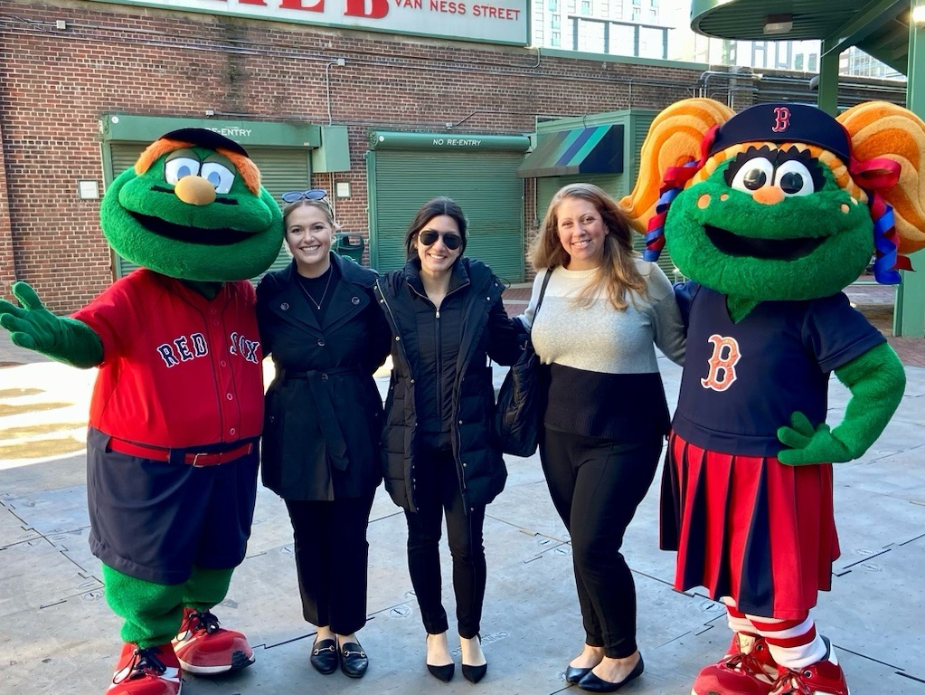 A group of women are posing for a picture with two mascots.