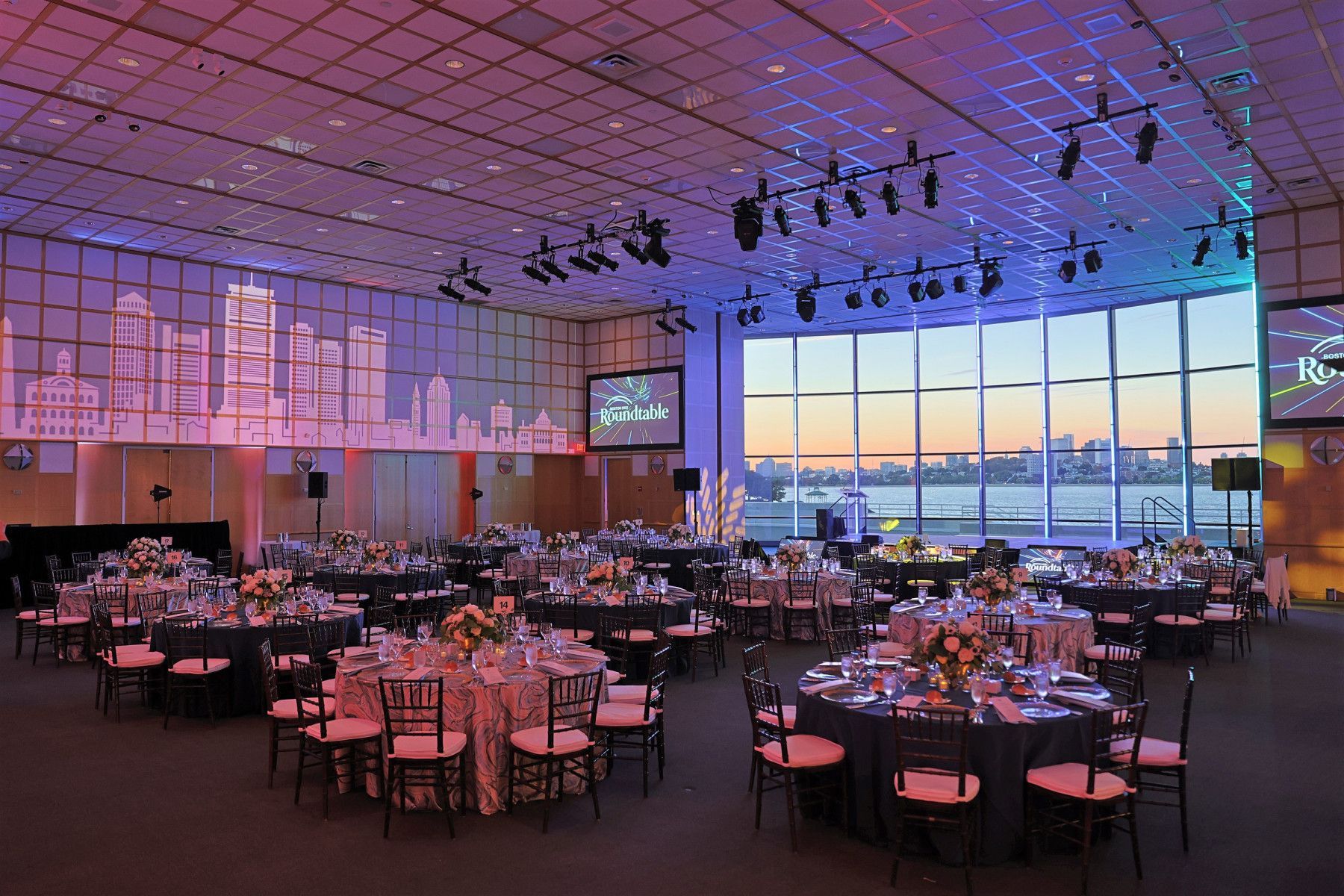 A large room with tables and chairs set up for a banquet