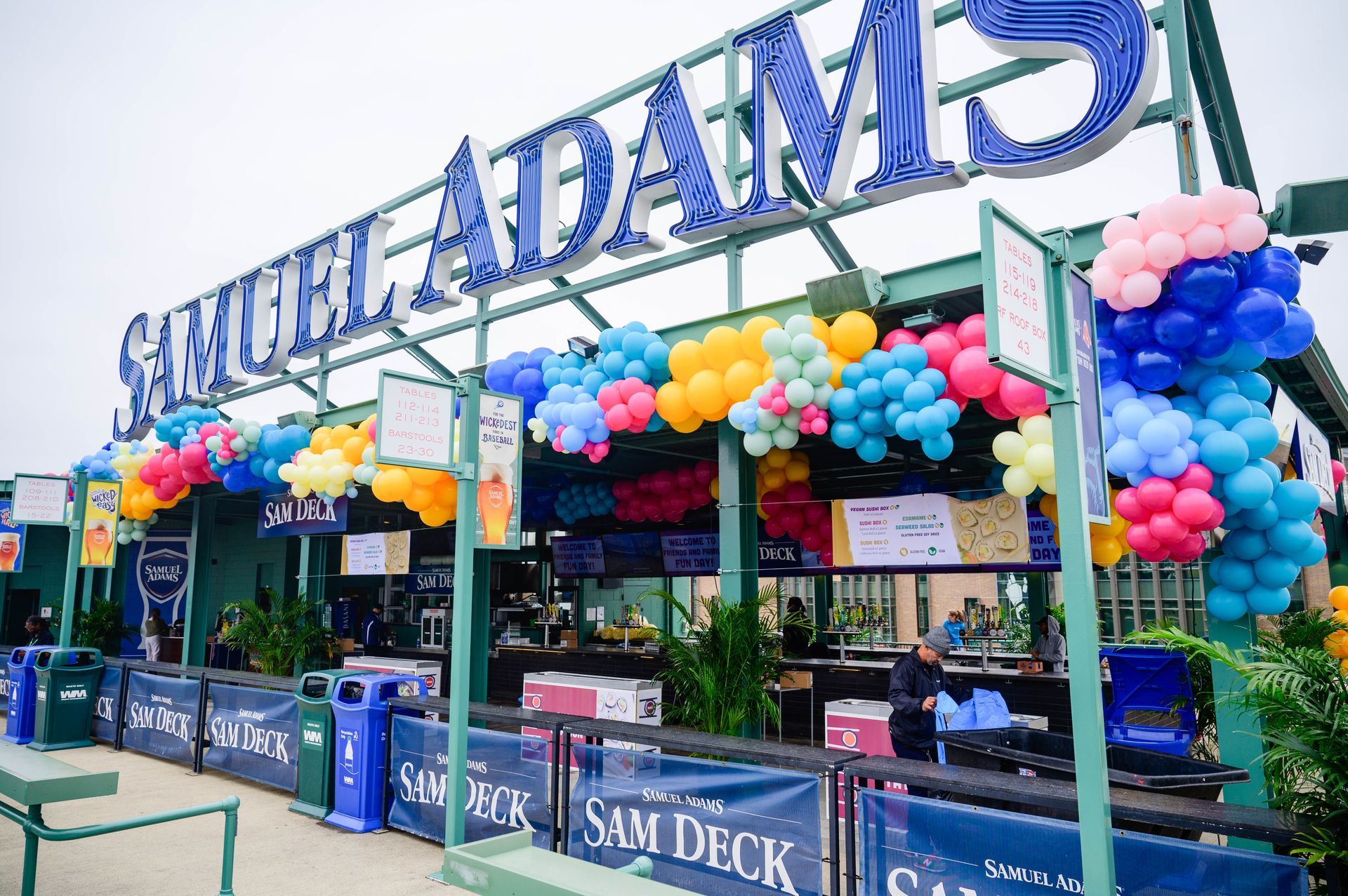Samuel Adams bar decorated with balloons at an outdoor event. Signage says