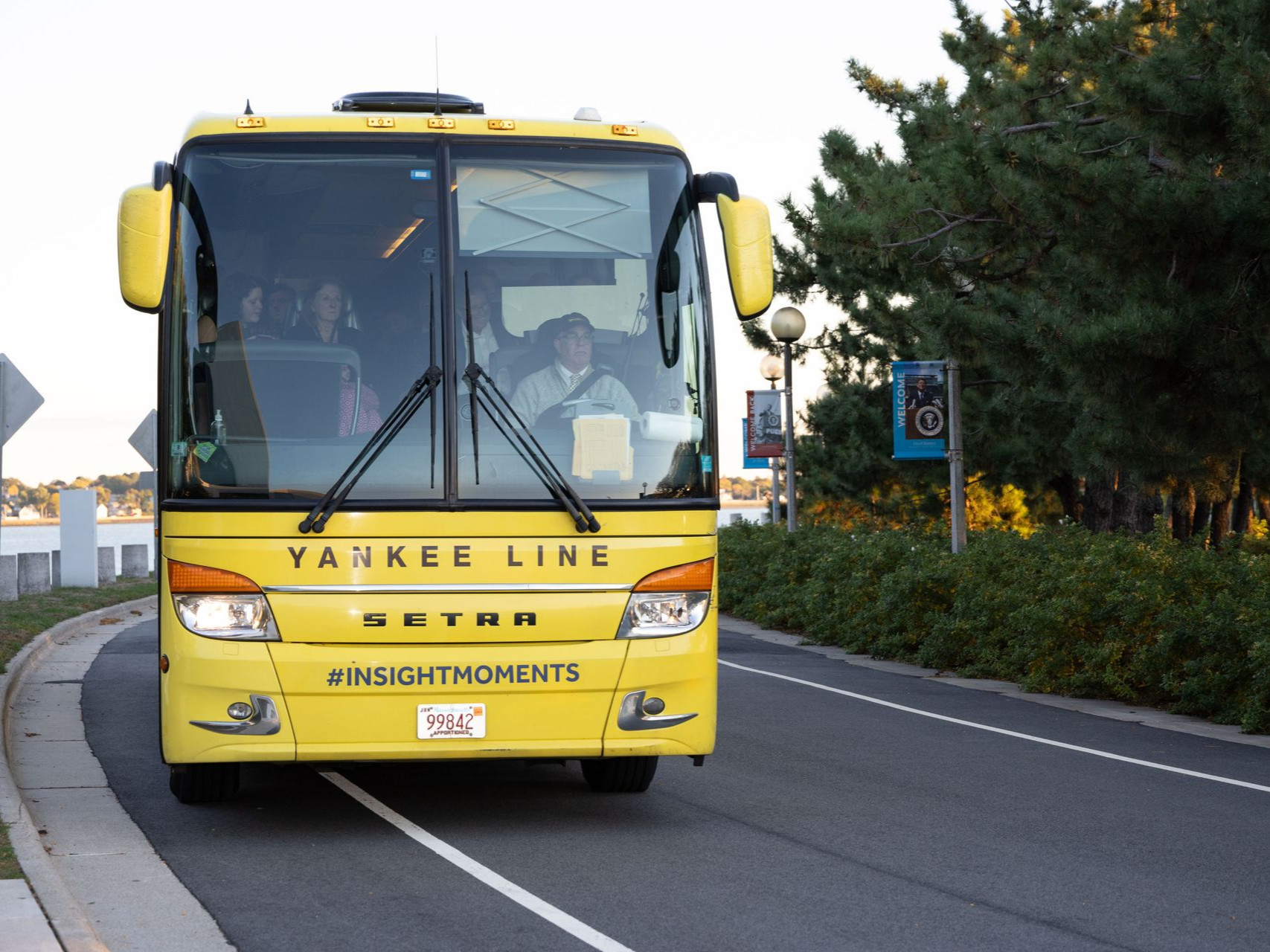 Yellow Yankee Line bus driving on road.