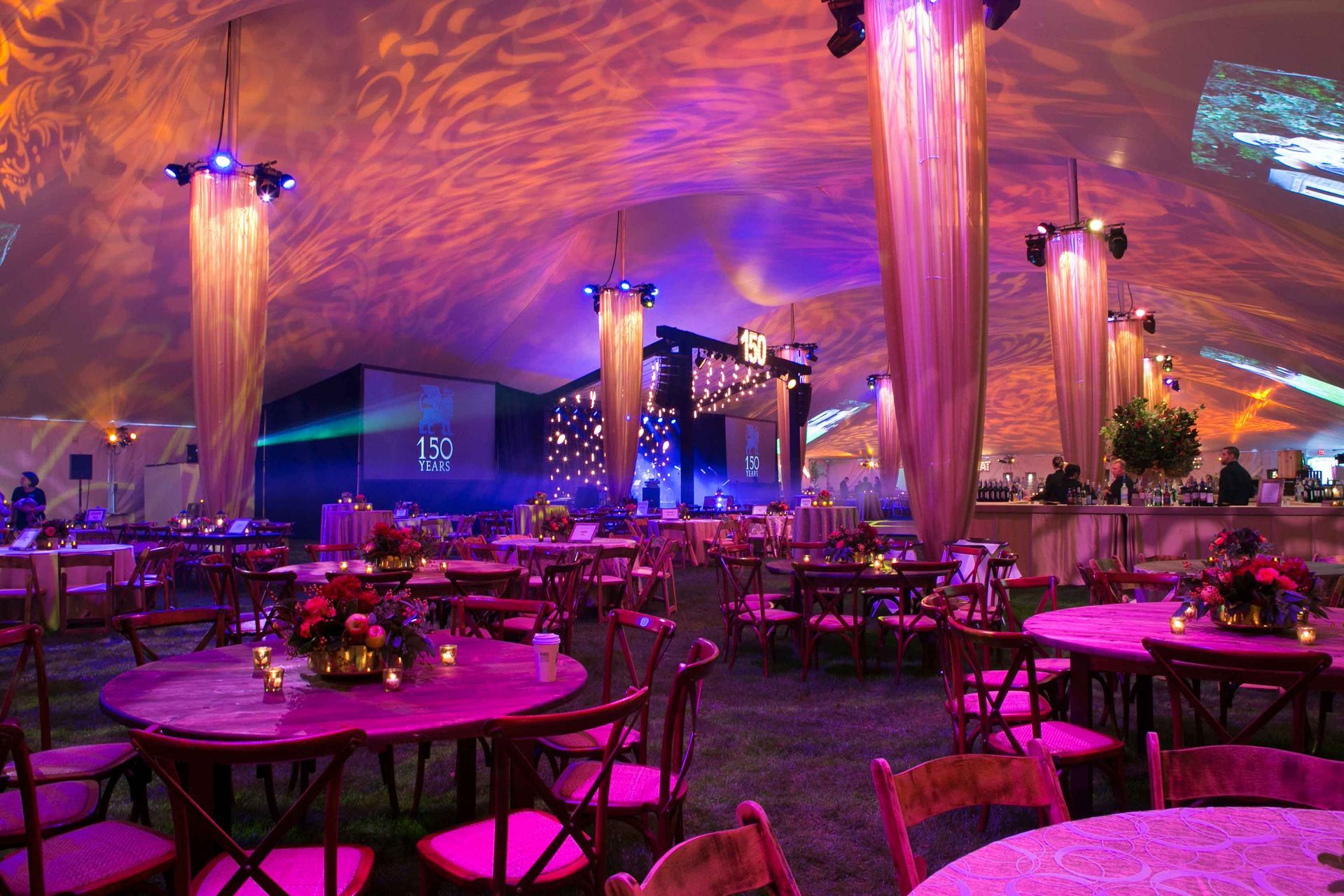 A large room with tables and chairs under a tent