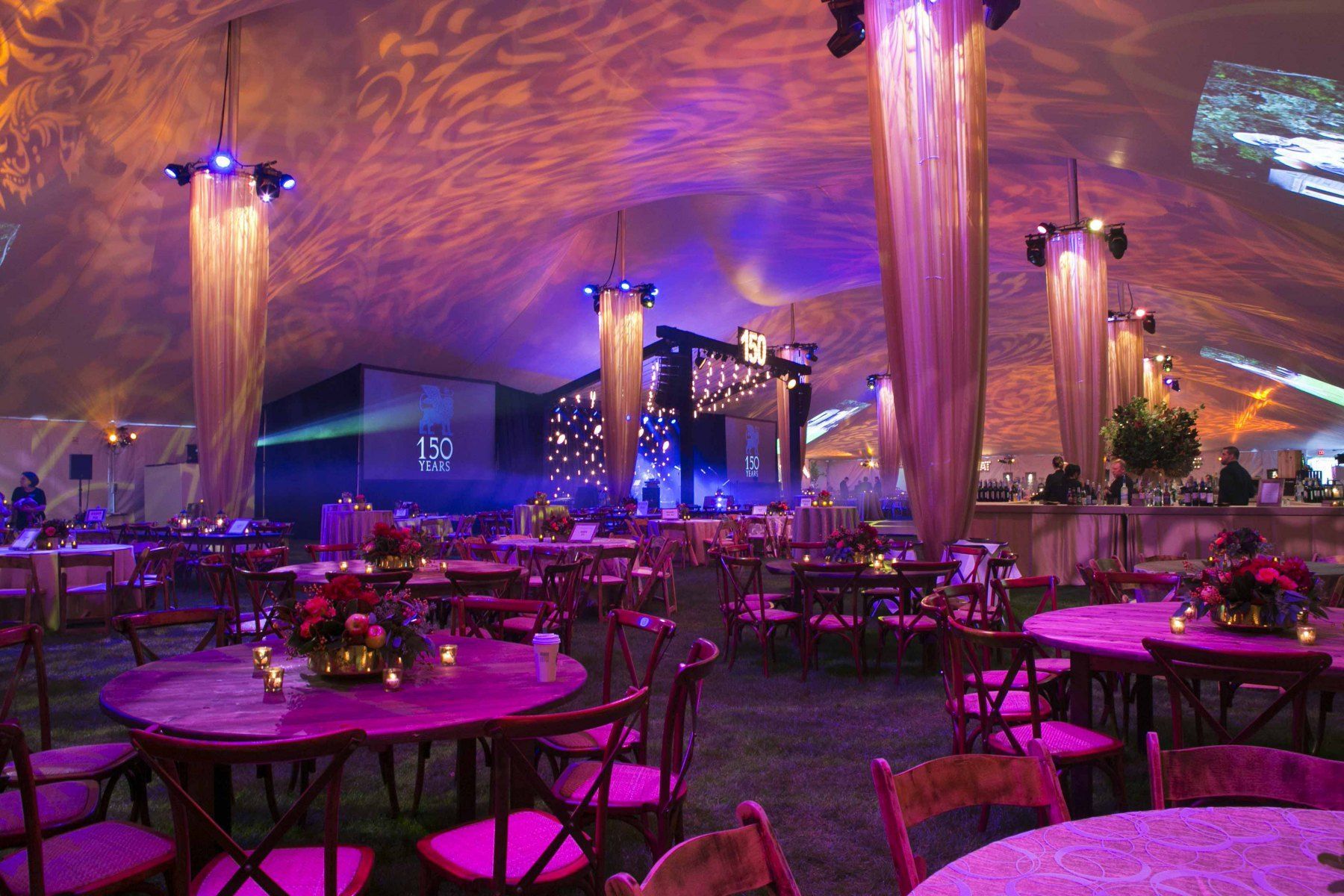 A large room with tables and chairs under a tent