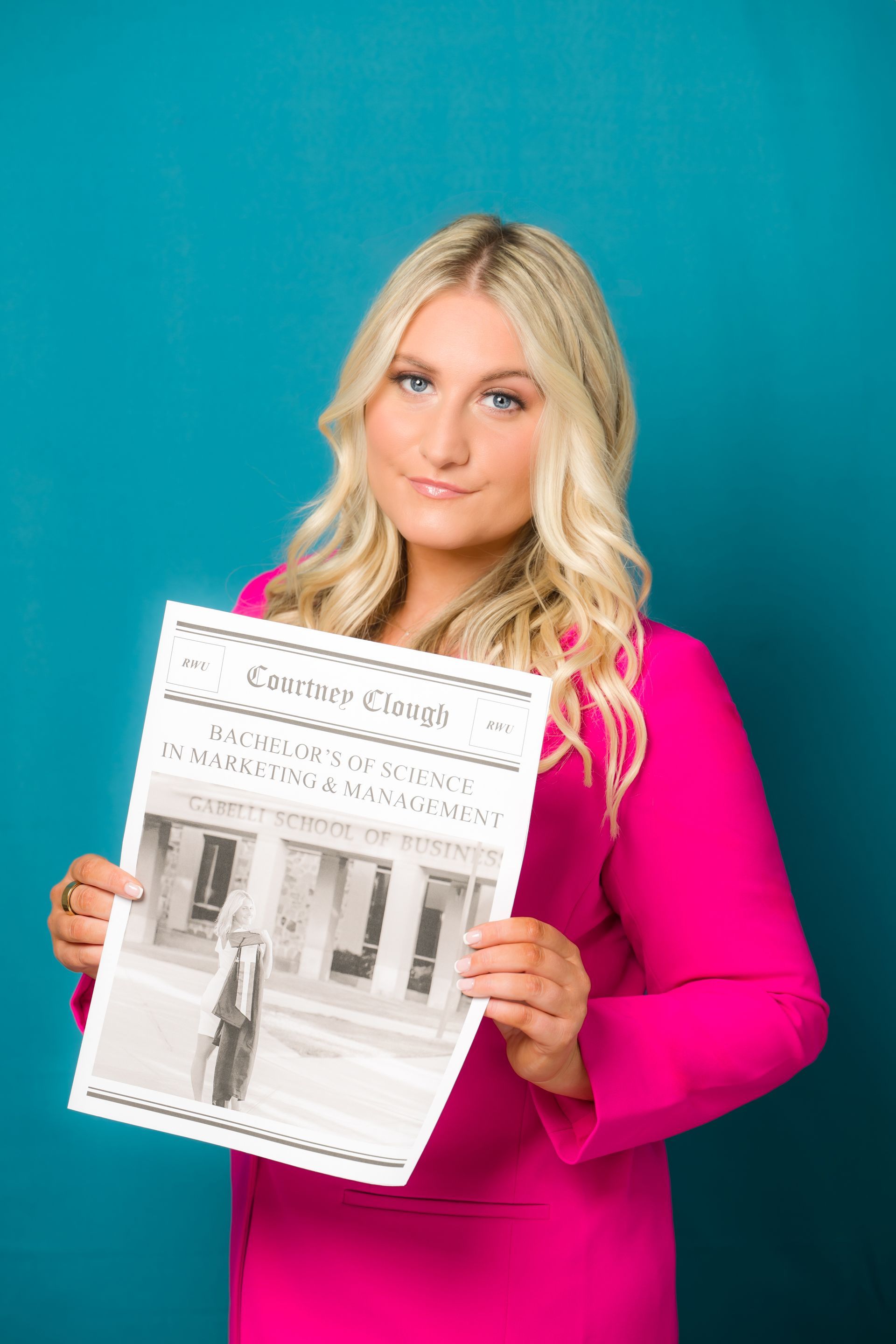 A woman in a pink dress is holding a newspaper.