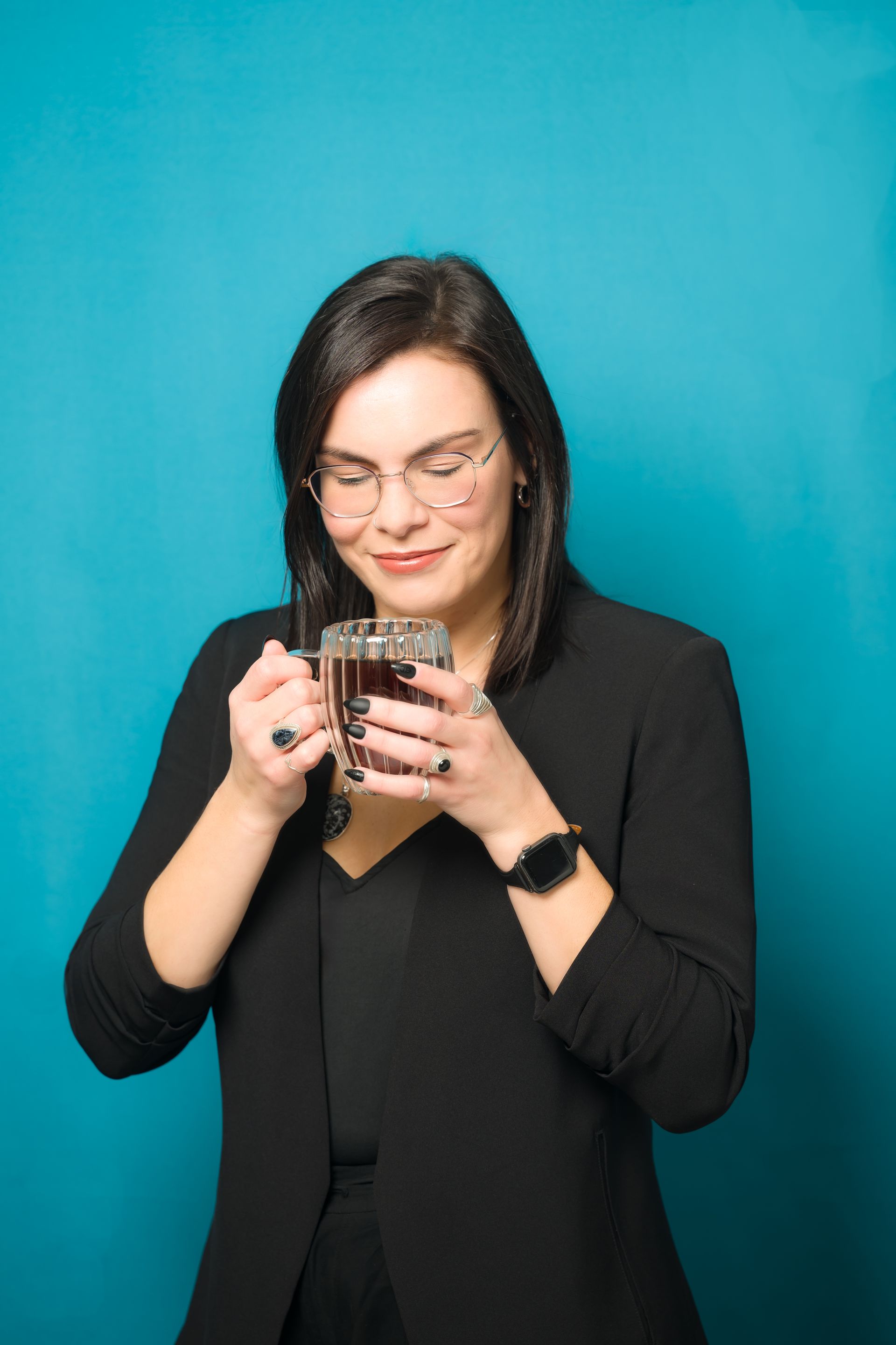 A woman is reading a book against a blue background.