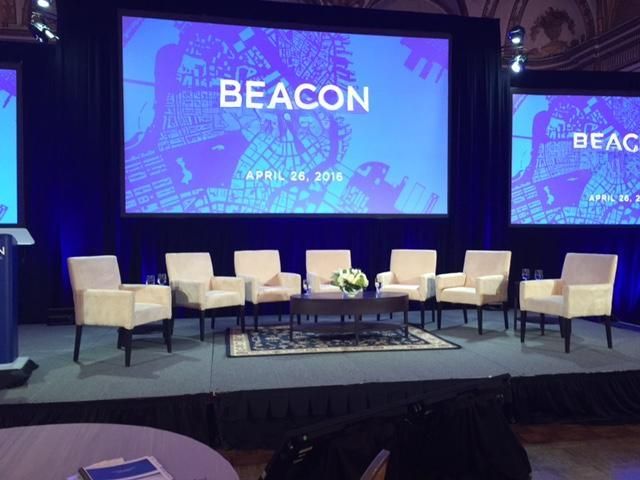 Panel discussion stage set: "BEACON" event, backdrop map, chairs, table, flowers, blue and white colors. April 20, 2016.