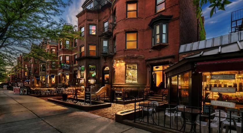 A brick building with a restaurant in front of it in a city.