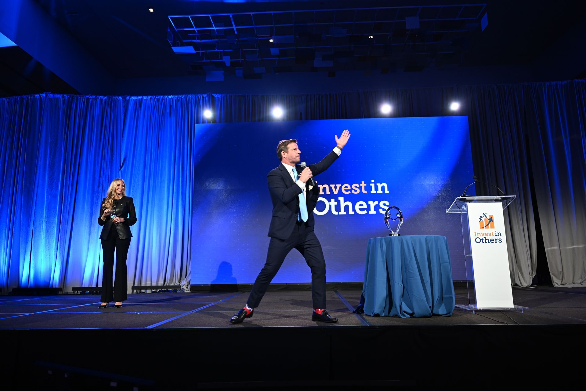 Two people on stage at an event with a