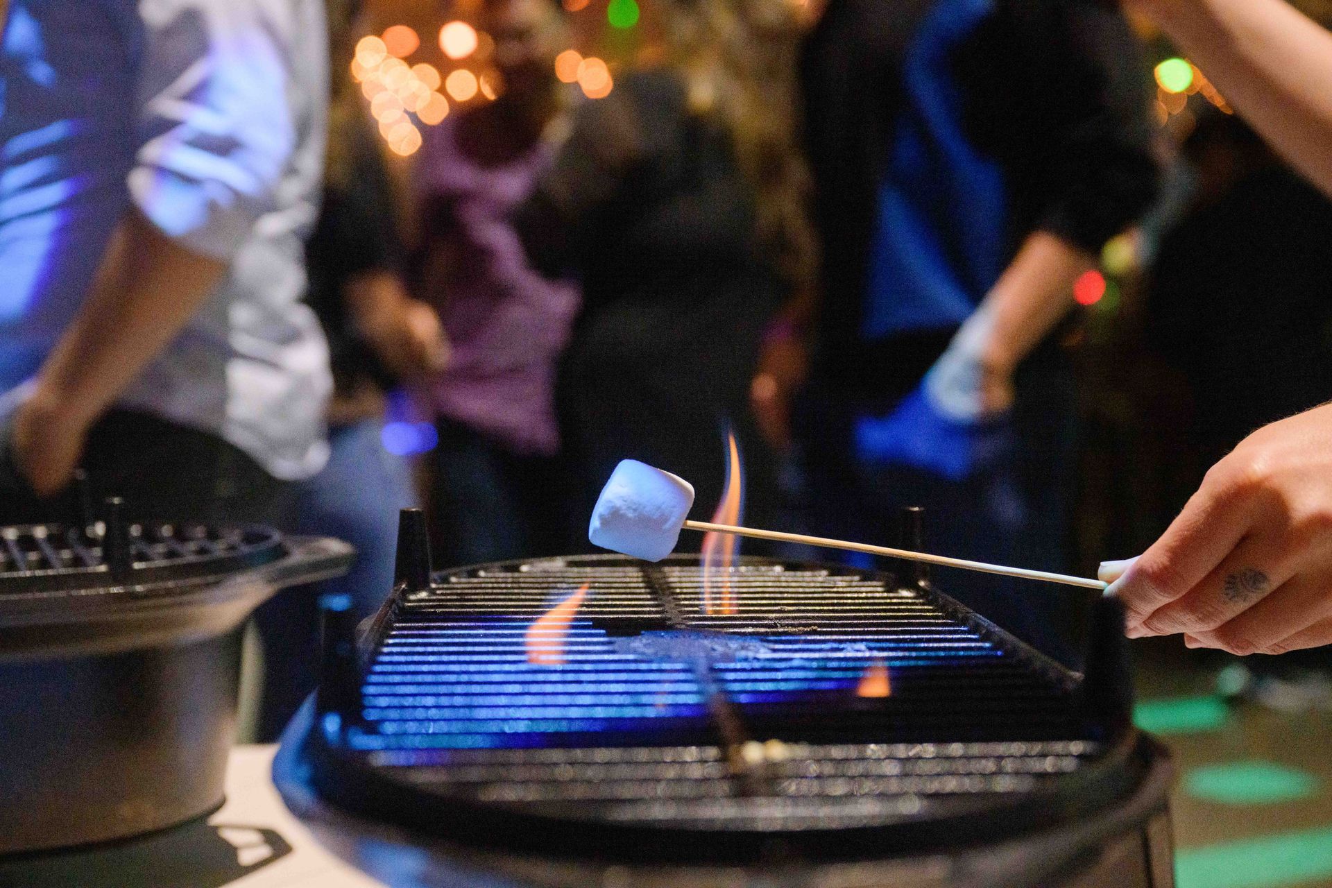 A person is roasting marshmallows on a grill.