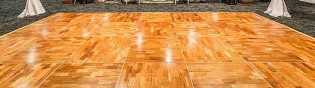 There is a large wooden dance floor in the middle of the room.