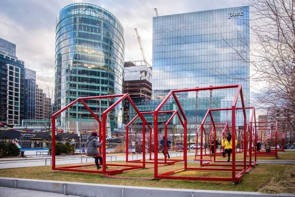 A group of people are playing in a park with a building in the background.