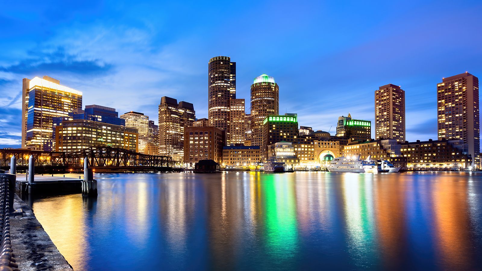 The city skyline is reflected in the water at night.
