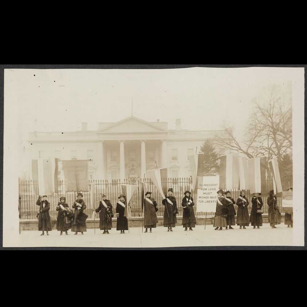 A group of women standing in front of the white house