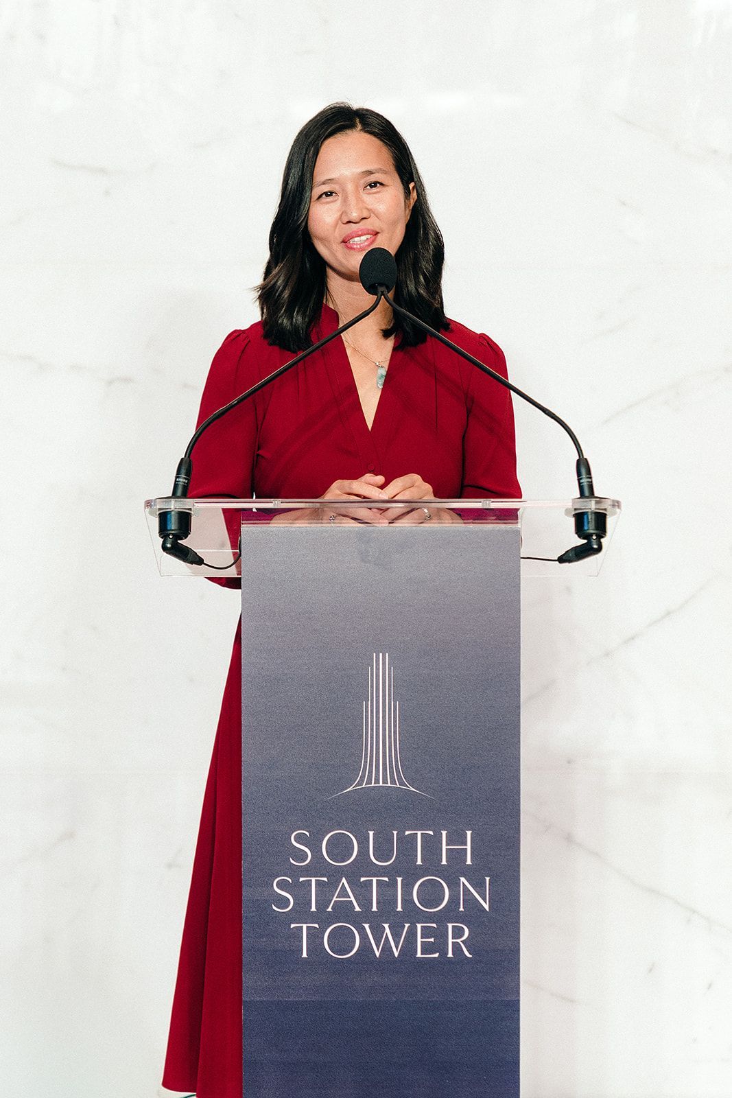 Woman speaking at podium labeled 