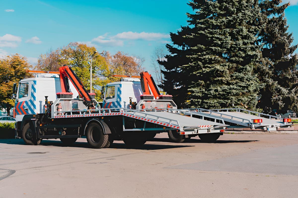 Two Tow Trucks Are Parked Next to Each Other in A Parking Lot — Mahers Smash Repairs in Nemingha, NSW