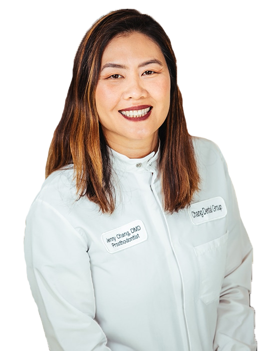 Woman in a white medical coat smiling against a plain white background