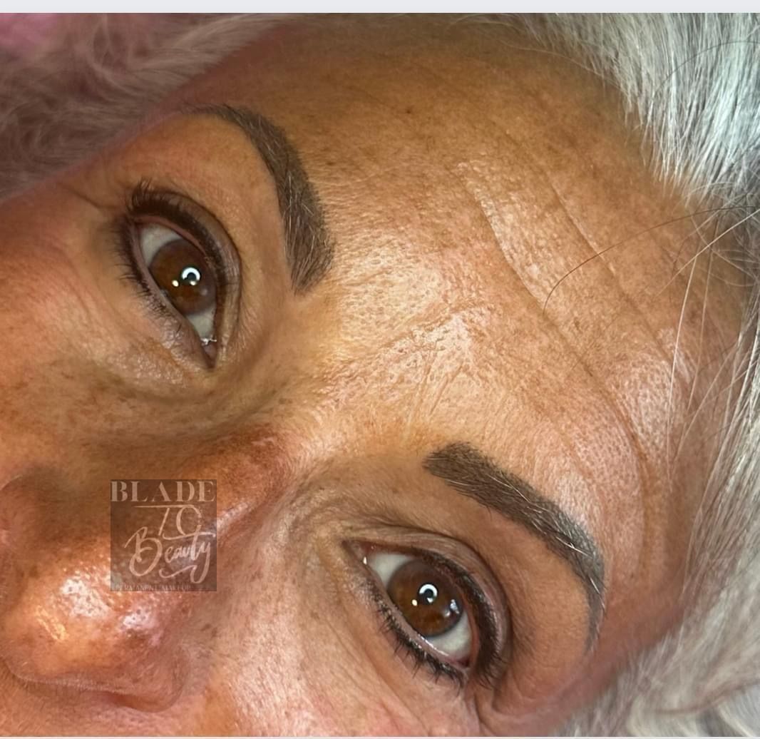 Close-up of a person’s eyes and forehead with white hair, looking at the camera.