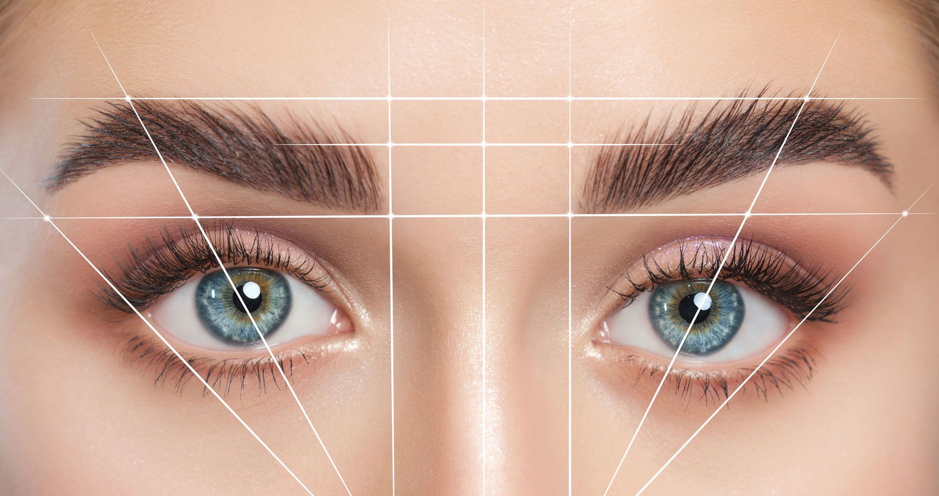 Close-up of two blue eyes with makeup and white alignment grid lines over the face
