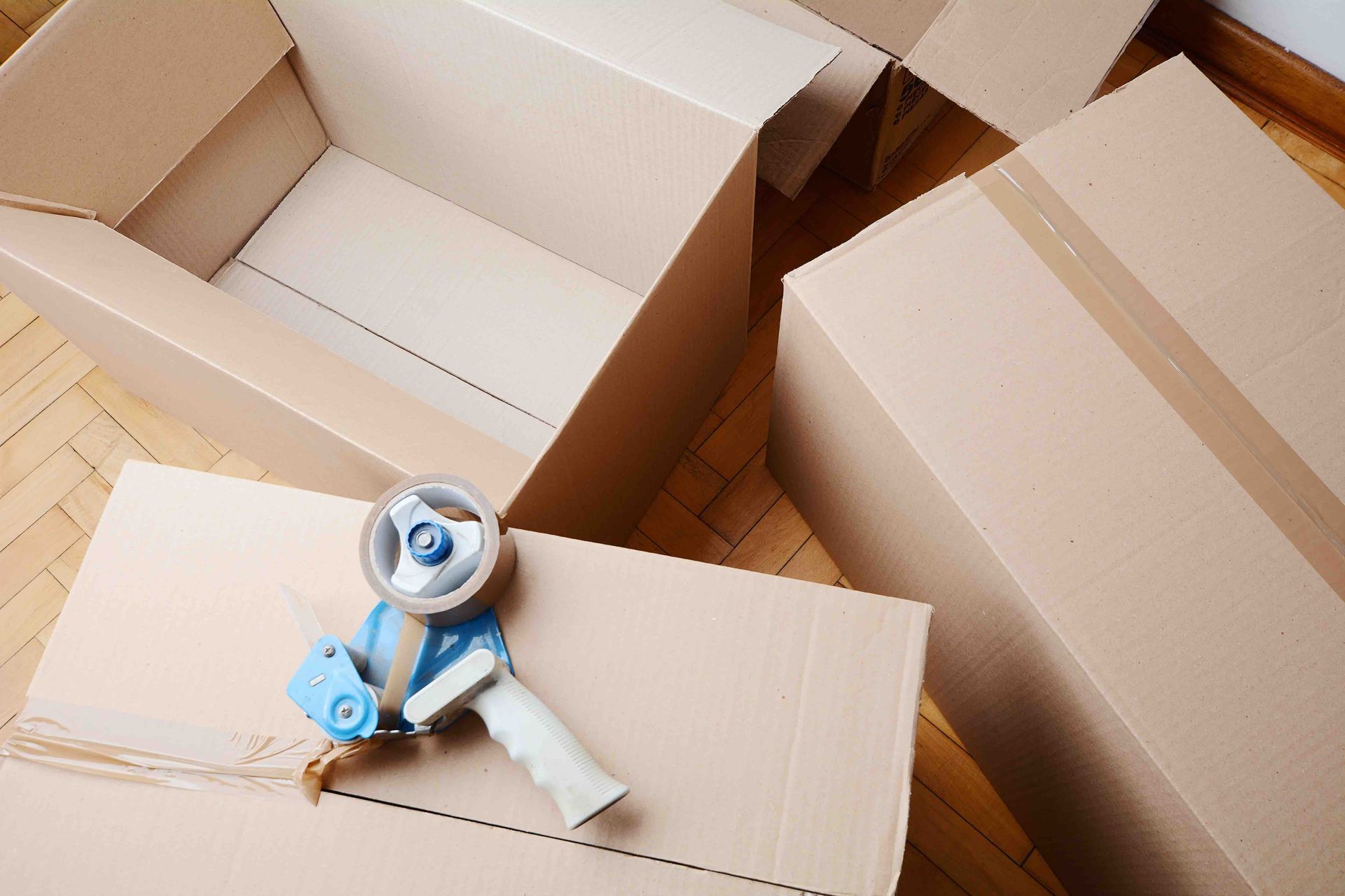 A tape dispenser is sitting on top of a cardboard box.