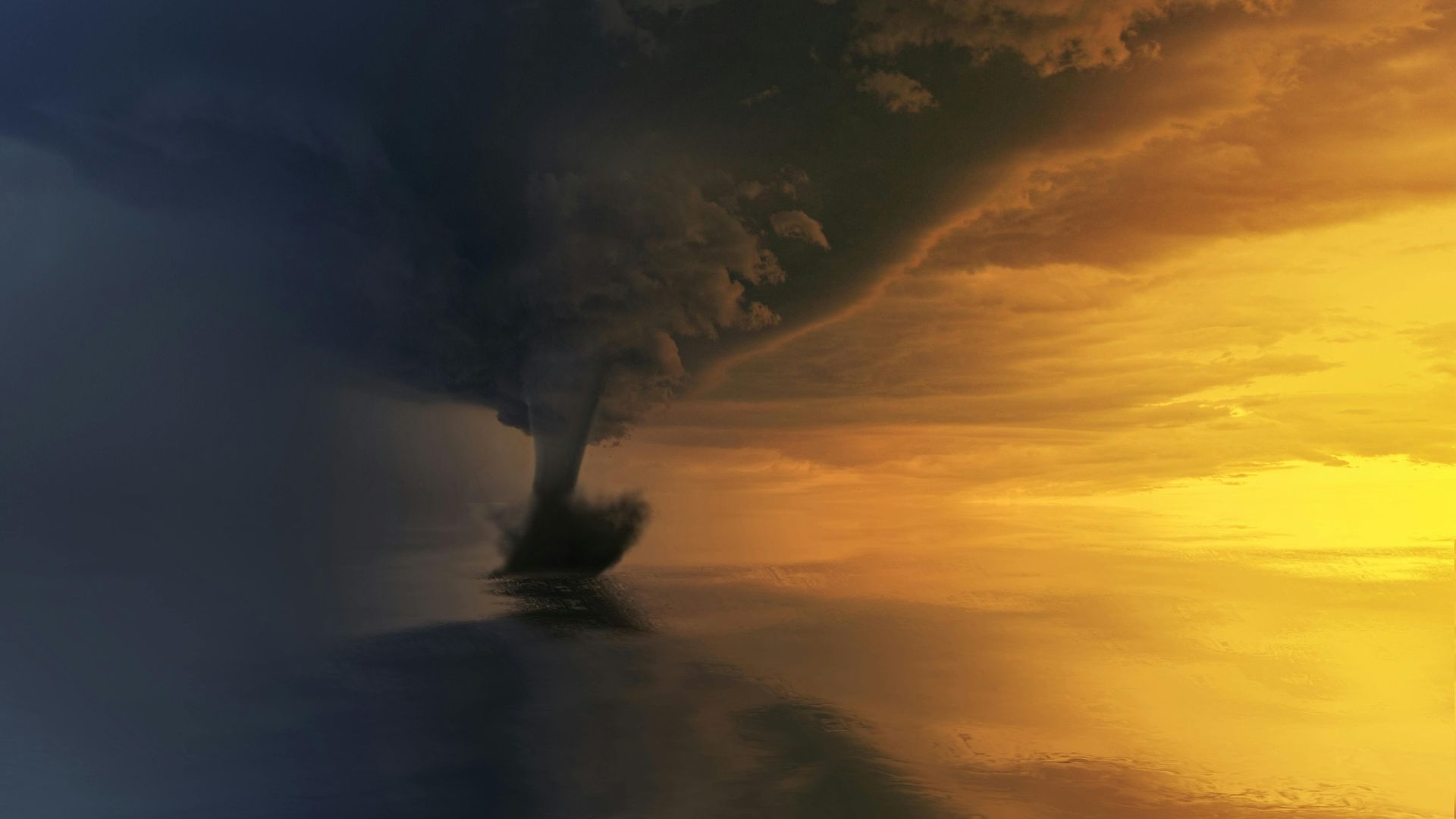 Storm cloud over a dark landscape at sunset, with golden light on the horizon