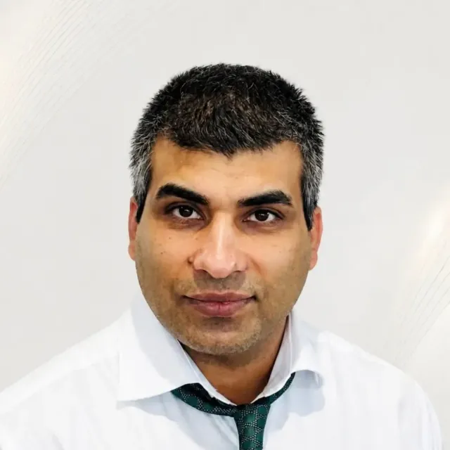 Portrait of a man in a white shirt and green tie against a light background