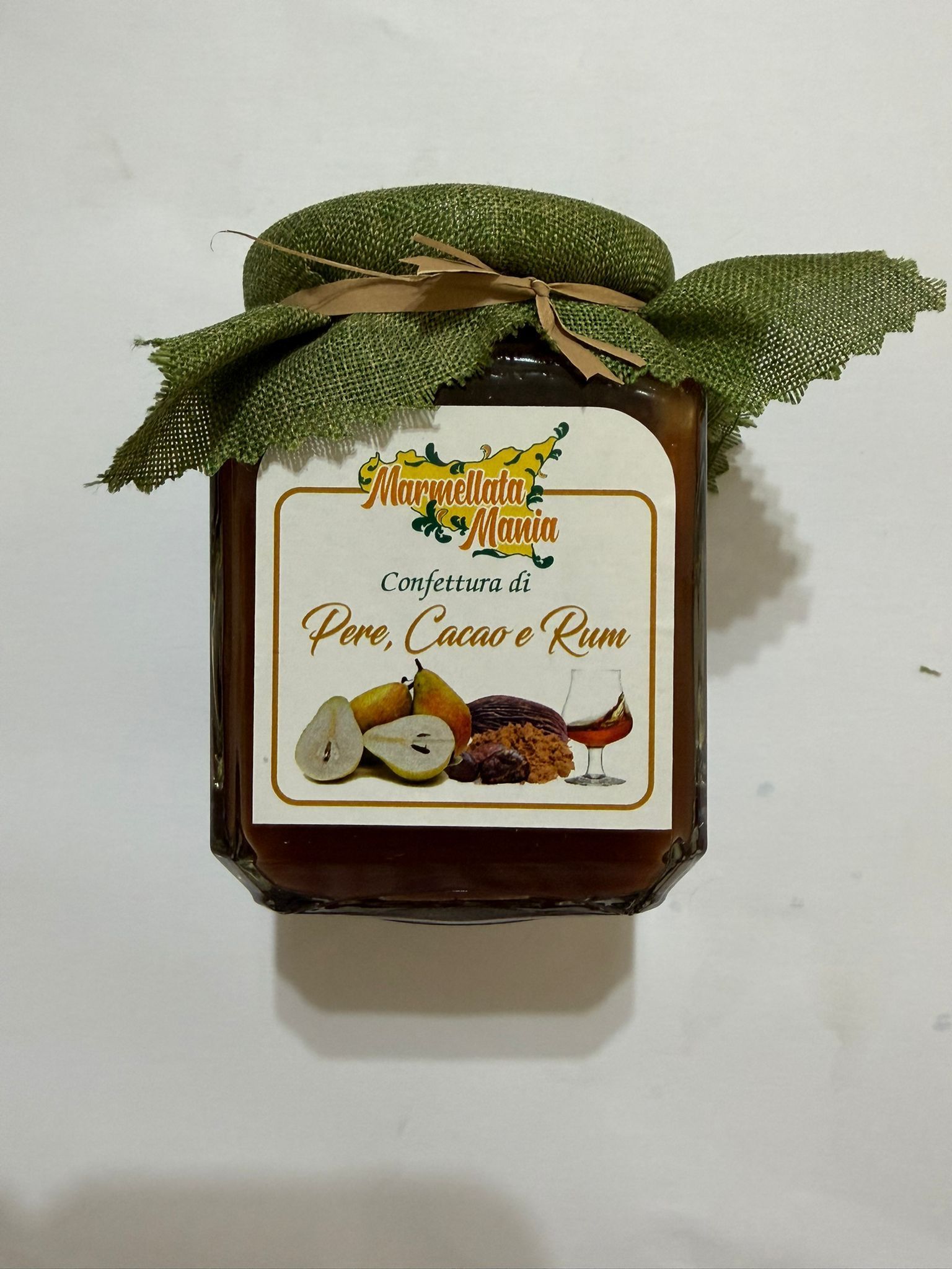 Vasetto quadrato di marmellata di mango verde con decorazione a foglia sulla parte superiore, su sfondo bianco.