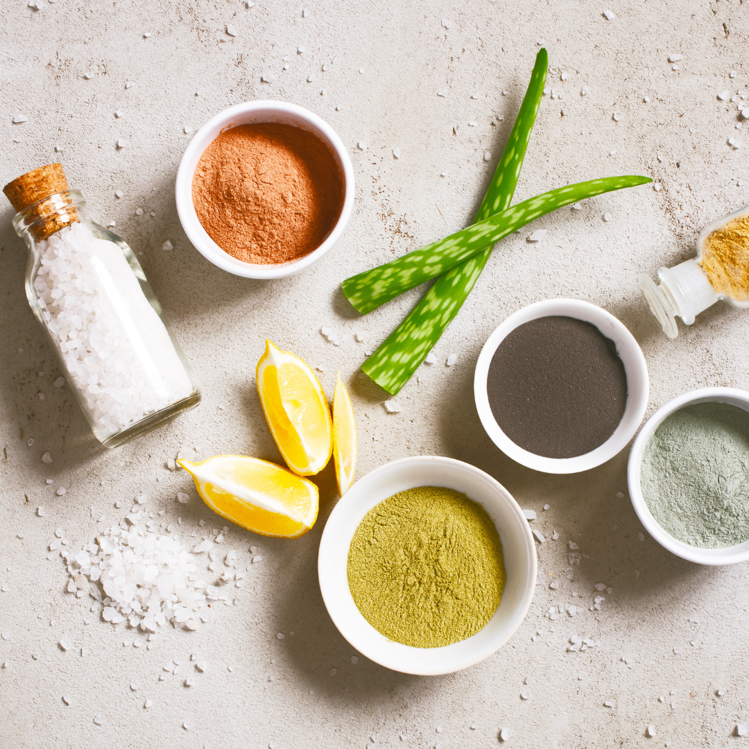 A table with bowls of different colored powders and lemon slices