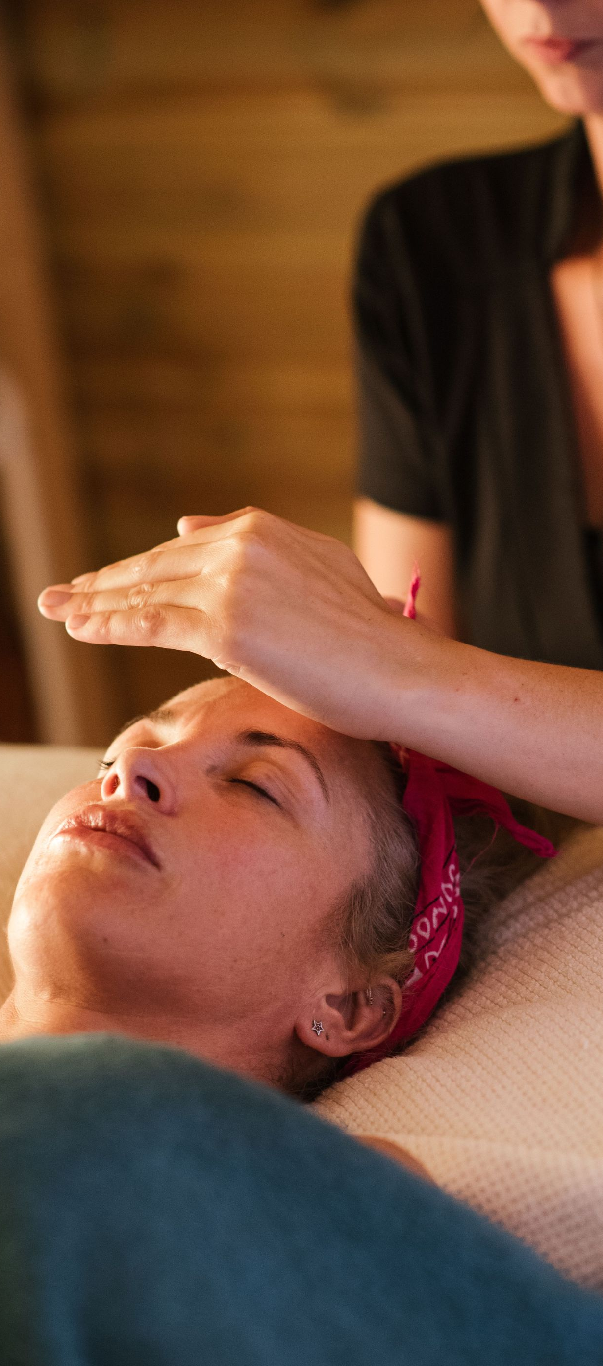 Person receiving a facial massage with pink head wrap in a spa setting