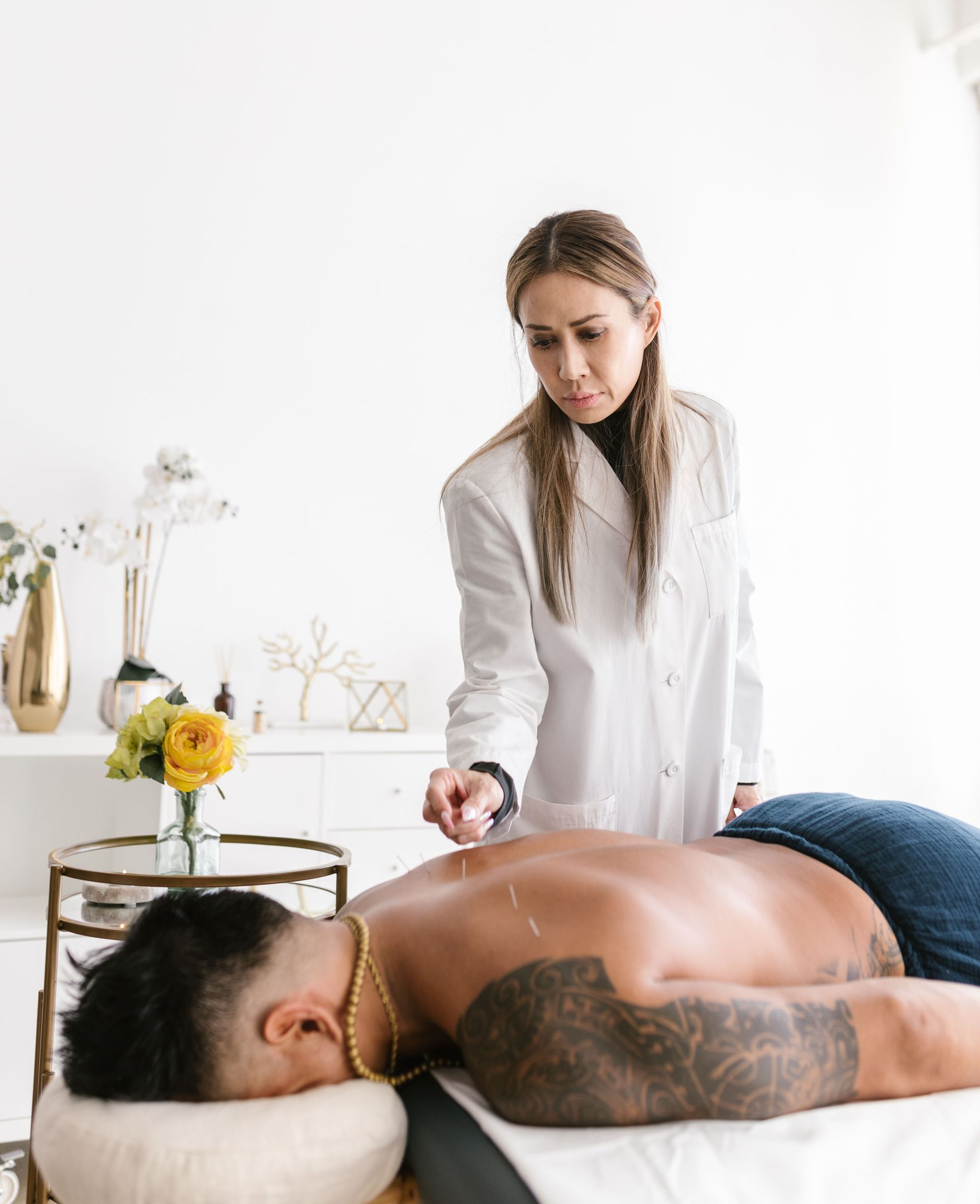 Massage therapist working on a client on a table in a bright spa room